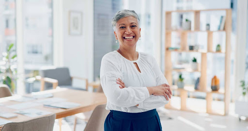 Mulher cabelo curto sorrindo e de braços cruzados