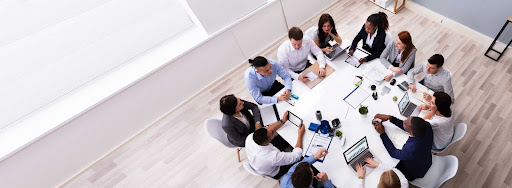 Pessoas reunidas em uma mesa do escritório