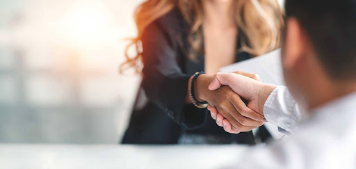 Homem e mulher apertando as mãos em processo de onboarding