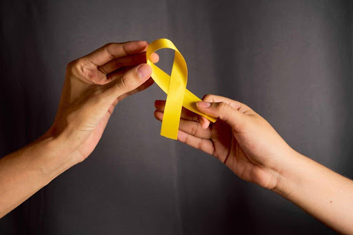 Mãos segurando fita do setembro amarelo