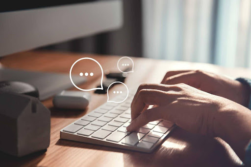 Mãos utilizando teclado do notebook para comunicação interna
